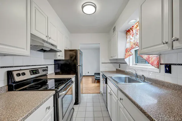 a kitchen with a sink a stove and cabinets