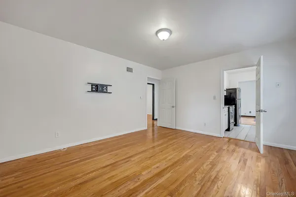a view of an empty room with wooden floor
