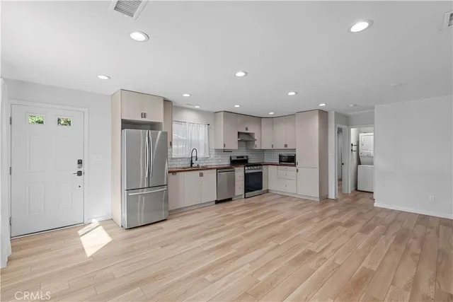 a kitchen with stainless steel appliances refrigerator sink and cabinets