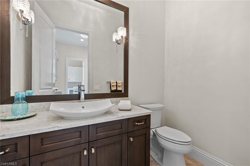 11681 Bald Eagle Way Naples, FL 34120 - Photo 24 of 50 a bathroom with a granite countertop sink a toilet and a mirror