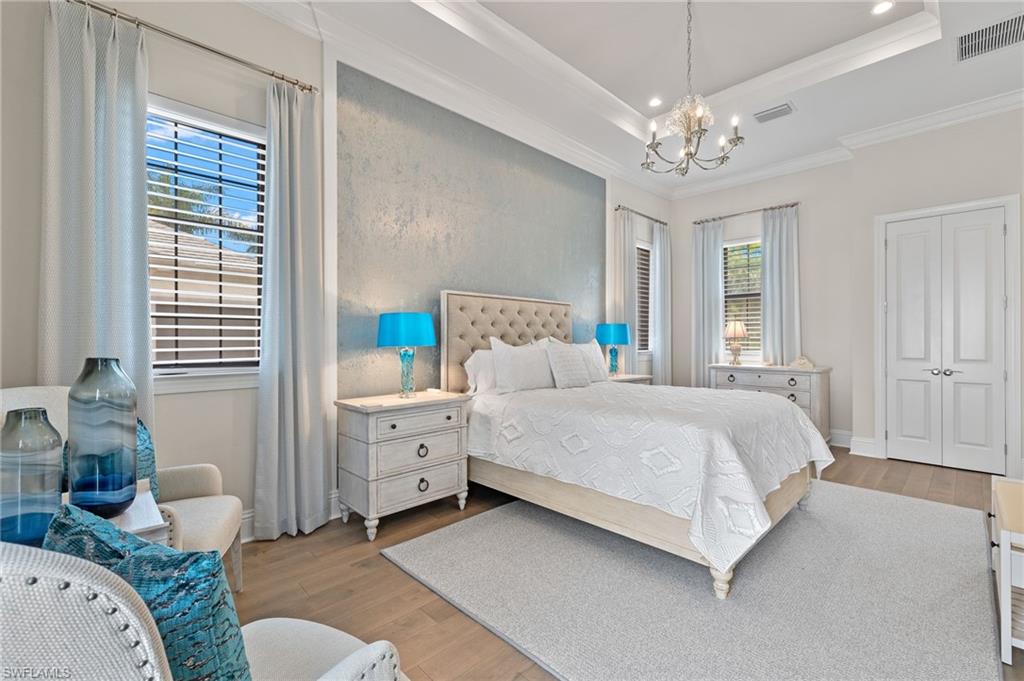 11681 Bald Eagle Way Naples, FL 34120 - Photo 27 of 50 a spacious bedroom with a bed and a chandelier