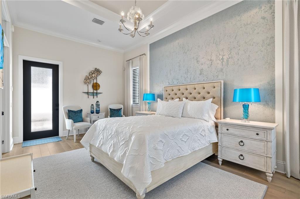 11681 Bald Eagle Way Naples, FL 34120 - Photo 28 of 50 a bedroom with a bed and a chandelier