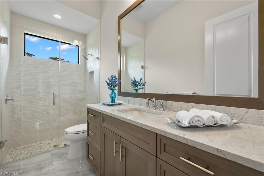 11681 Bald Eagle Way Naples, FL 34120 - Photo 32 of 50 a bathroom with a granite countertop sink a toilet and a mirror