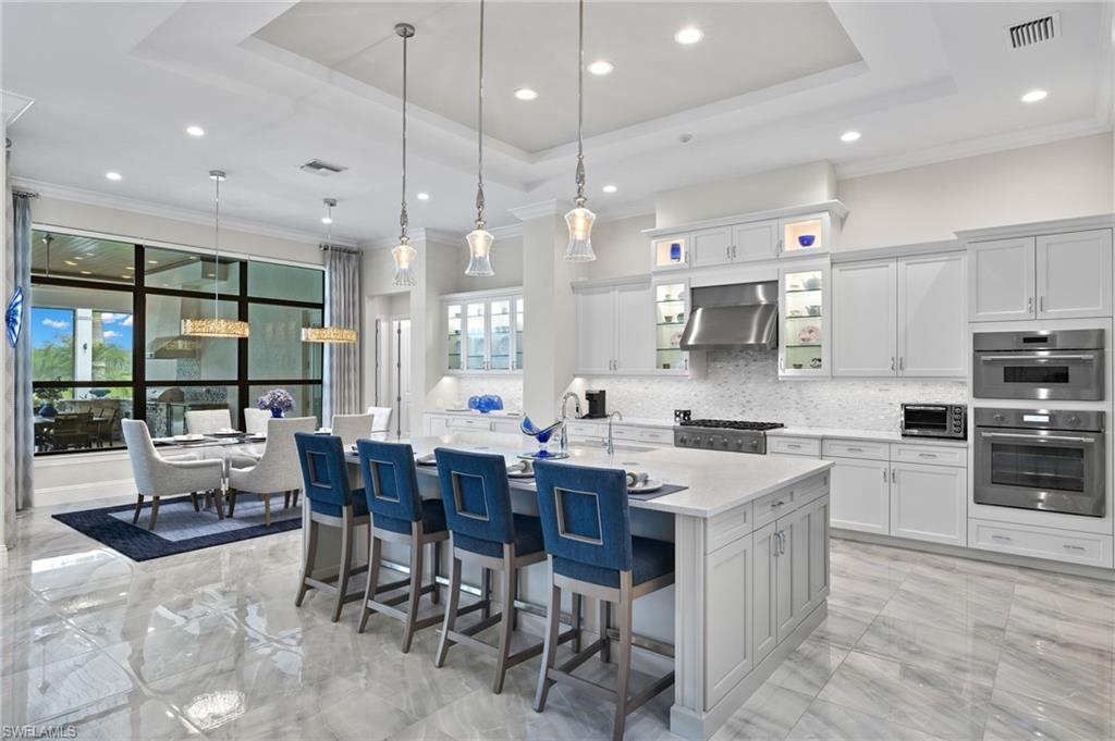 11681 Bald Eagle Way Naples, FL 34120 - Photo 6 of 50 a large kitchen with a table and chairs