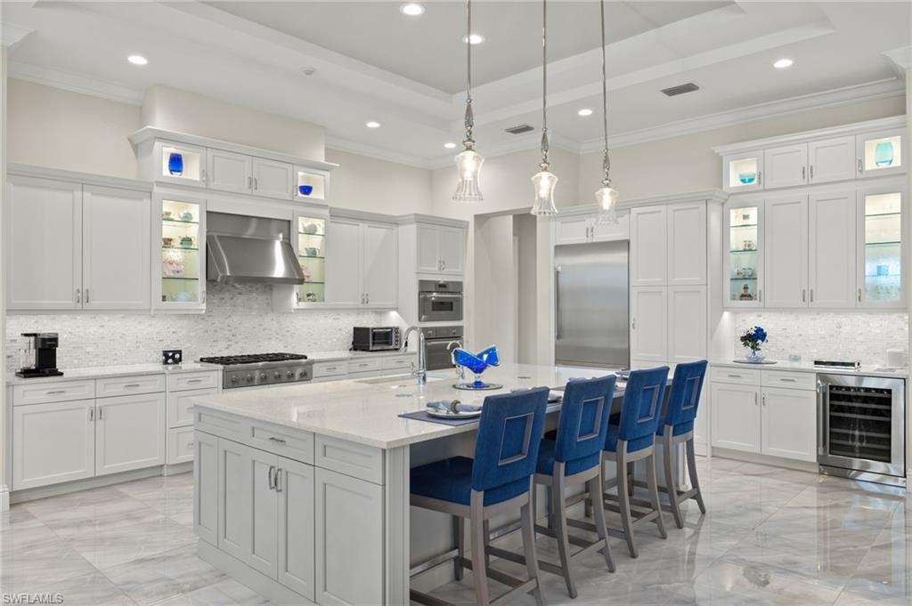 11681 Bald Eagle Way Naples, FL 34120 - Photo 7 of 50 a kitchen with stainless steel appliances kitchen island granite countertop a sink a stove a dining table and chairs