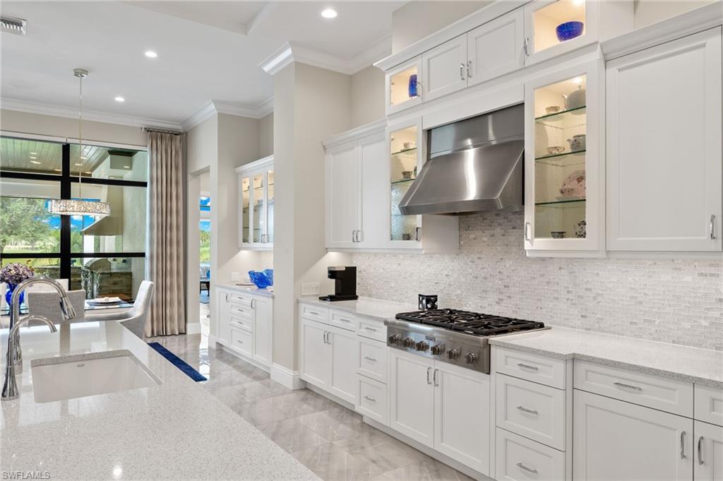 11681 Bald Eagle Way Naples, FL 34120 - Photo 10 of 50 a kitchen with stainless steel appliances a sink stove and cabinets