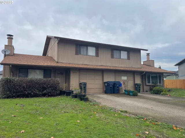 a front view of a house with a yard and potted plants