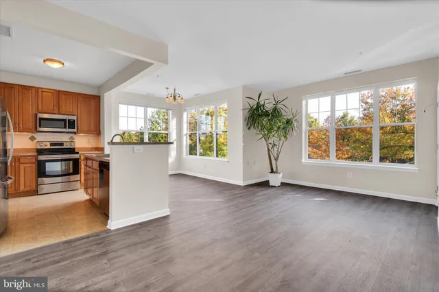 an empty room with kitchen and windows