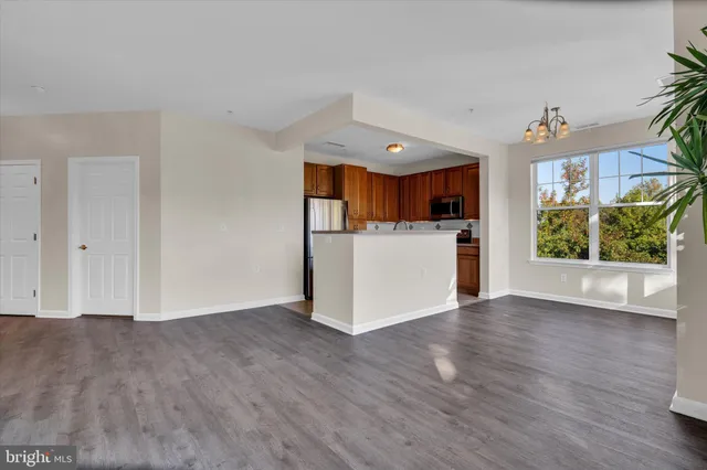a view of a kitchen with wooden floor and a window