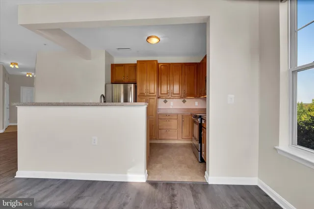 a view of a kitchen with a refrigerator wooden cabinets and a refrigerator
