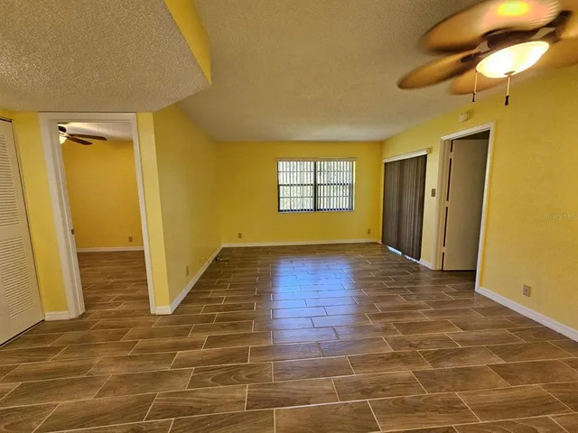 a view of an empty room with window and wooden floor