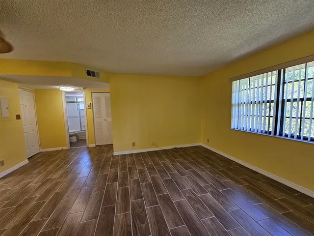 a view of empty room with wooden floor