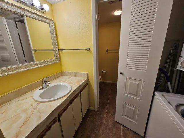 a view of an empty room with wooden floor and a ceiling fan