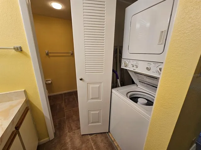 a view of an empty room with wooden floor and a ceiling fan