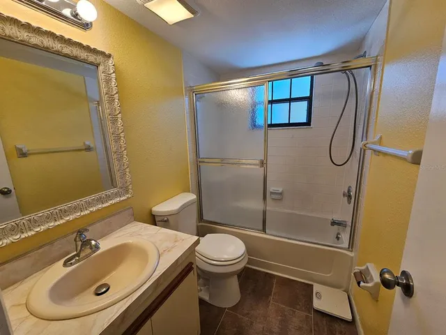 a view of a patio with a table and chairs under an umbrella