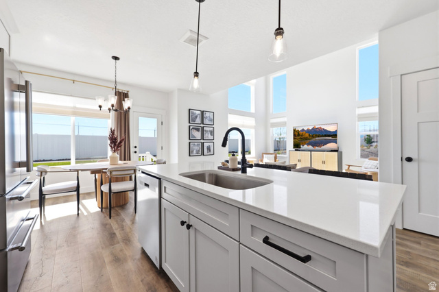 4646 Alder Drive, Unit 223 Mapleton, UT 84664 - Photo 4 of 35 Kitchen island featuring a stainless steel sink, black faucet, and white countertop