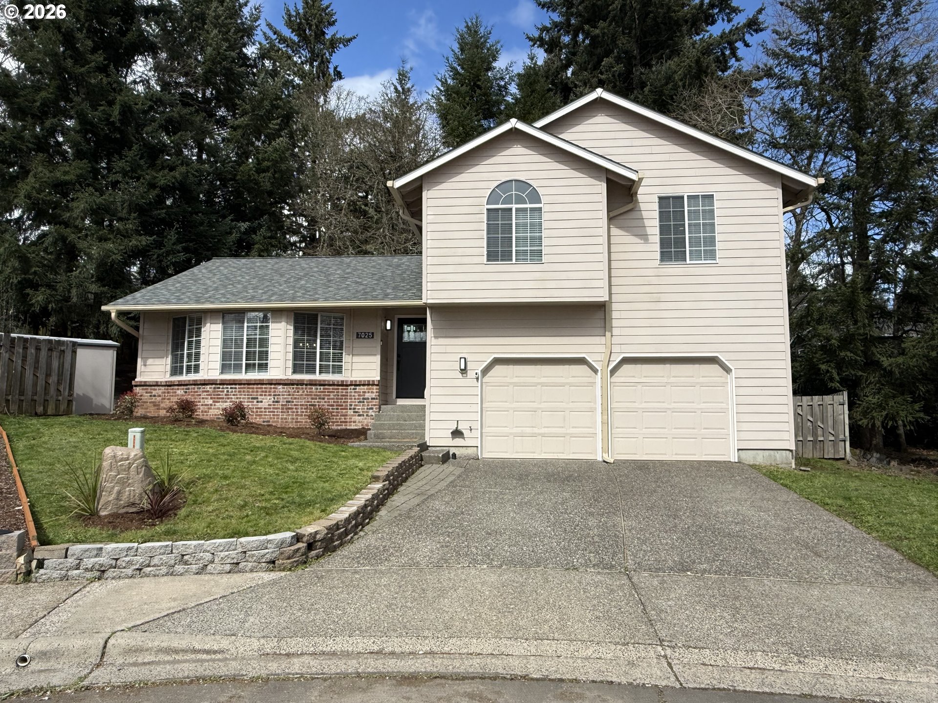 7025 Southwest 164th Terrace Beaverton, OR 97007 - Photo 1 of 28 a view of a white house next to a yard and large trees