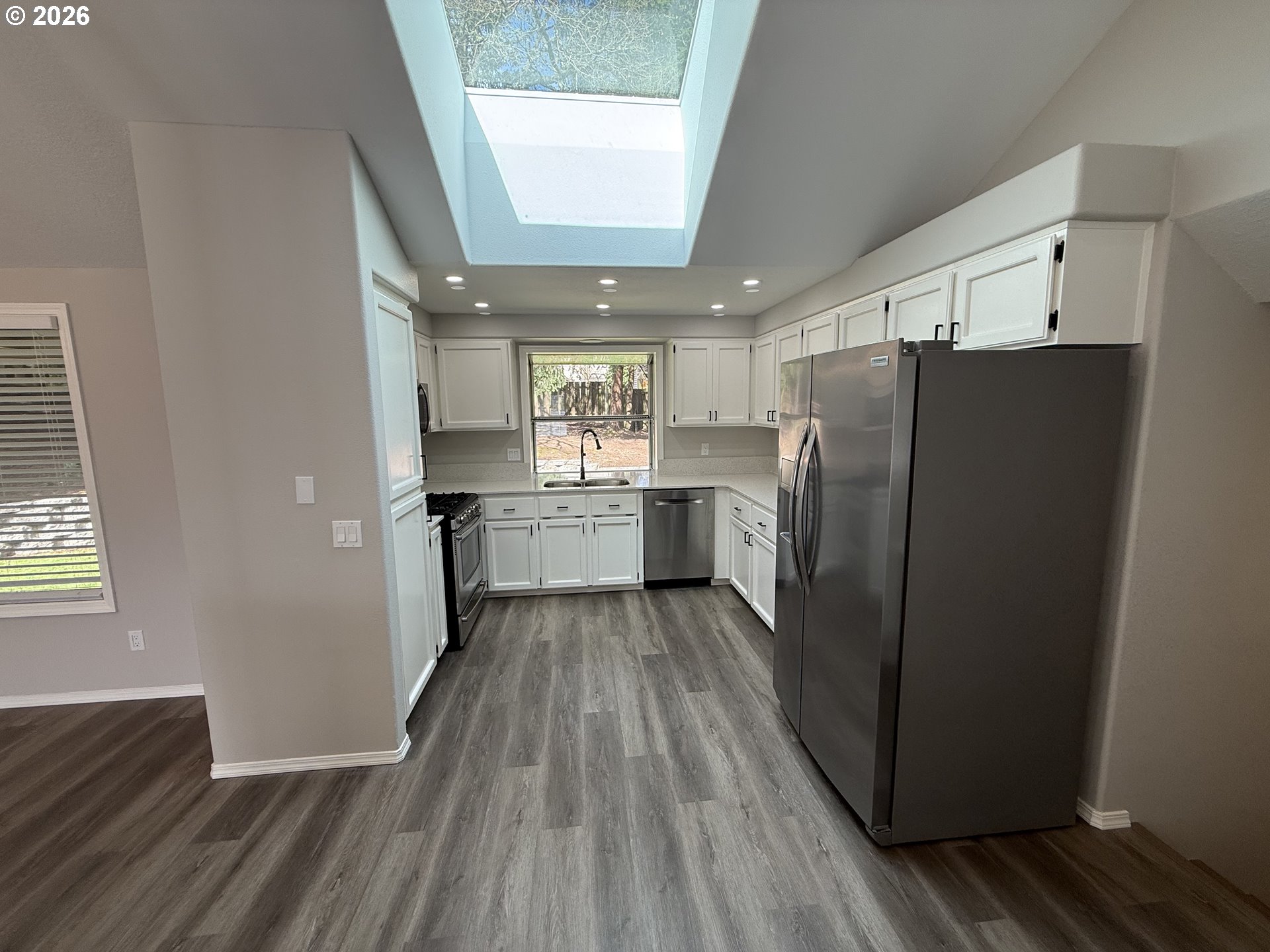 7025 Southwest 164th Terrace Beaverton, OR 97007 - Photo 4 of 28 a kitchen with a refrigerator and wooden floor