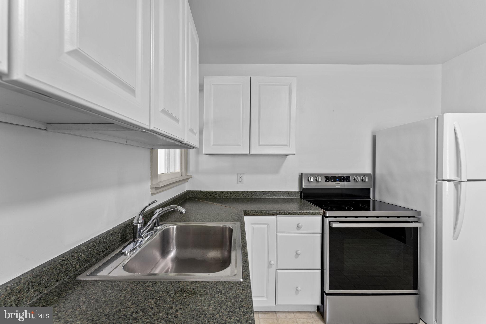 216 Walnut Street Berryville, VA 22611 - Photo 29 of 36 a kitchen with granite countertop a sink stove and refrigerator