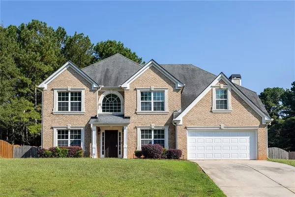 a front view of a house with a yard and garage