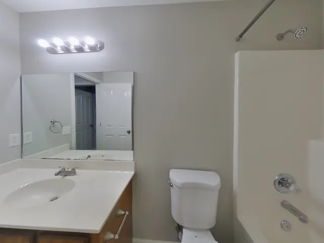 a view of an empty room with a chandelier fan