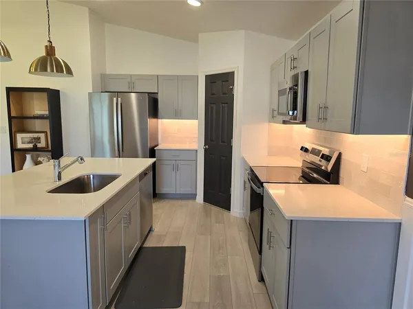 a kitchen with stainless steel appliances granite countertop a sink stove and refrigerator