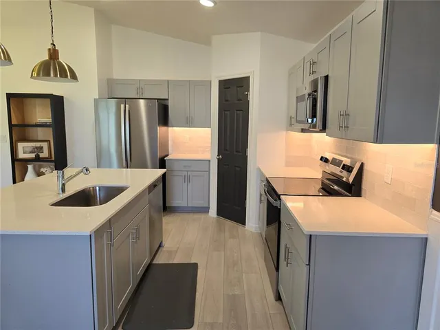 a kitchen with stainless steel appliances granite countertop a sink stove and refrigerator