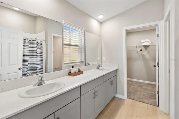 a bathroom with double vanity sinks and a mirror