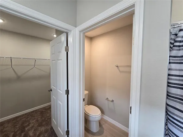 a bathroom with a granite countertop toilet and a shower