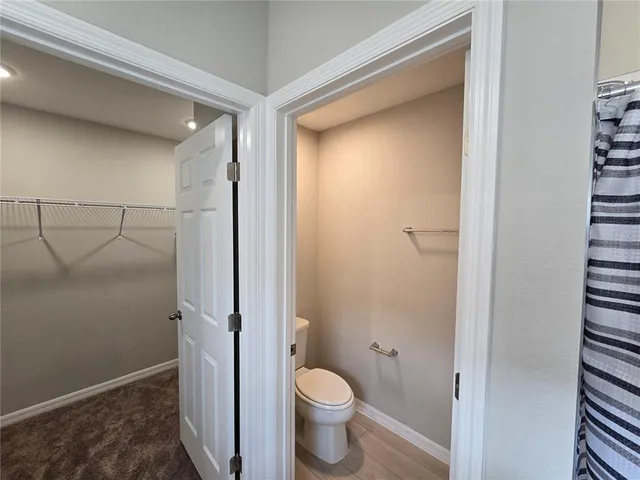 a bathroom with a granite countertop toilet and a shower