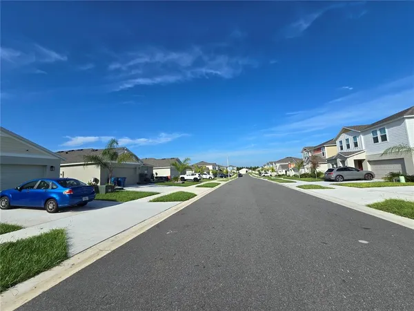 a view of a city street with a car parked on the road