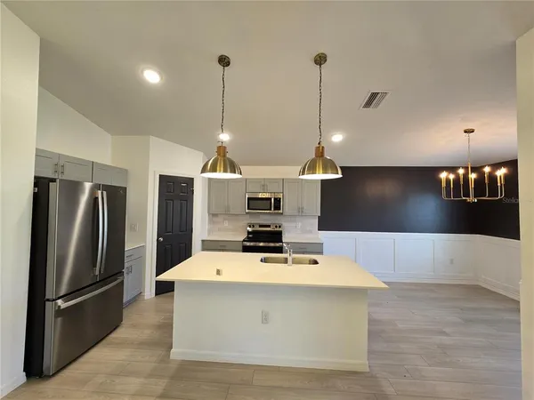 a kitchen with stainless steel appliances a stove a refrigerator and a sink