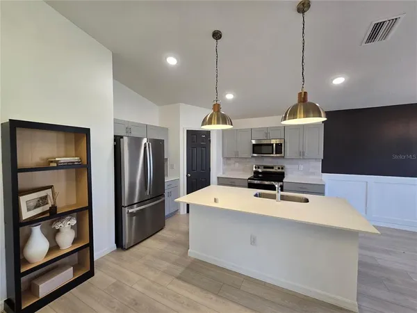 a kitchen with stainless steel appliances a refrigerator sink and microwave