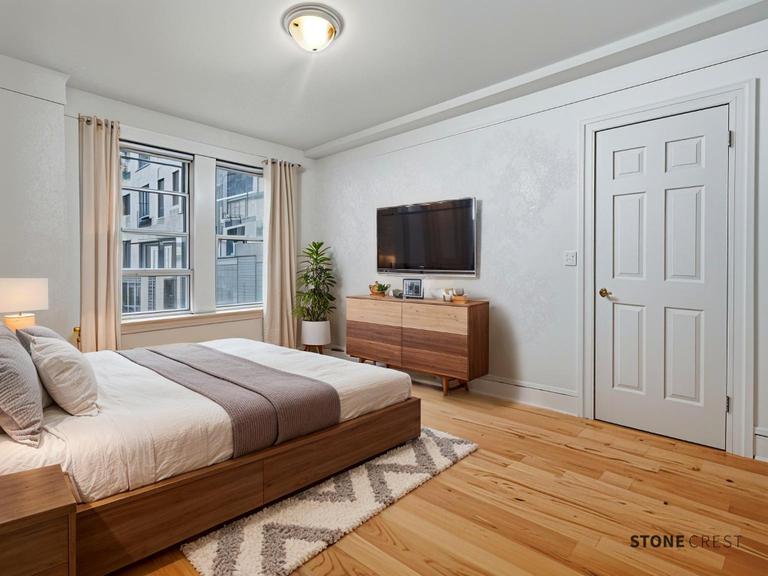 425 Riverside Drive, Unit 8G Manhattan, NY 10025 - Photo 4 of 16 a bedroom with a bed and a flat screen tv