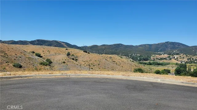 a view of a mountain range with a wooden fence