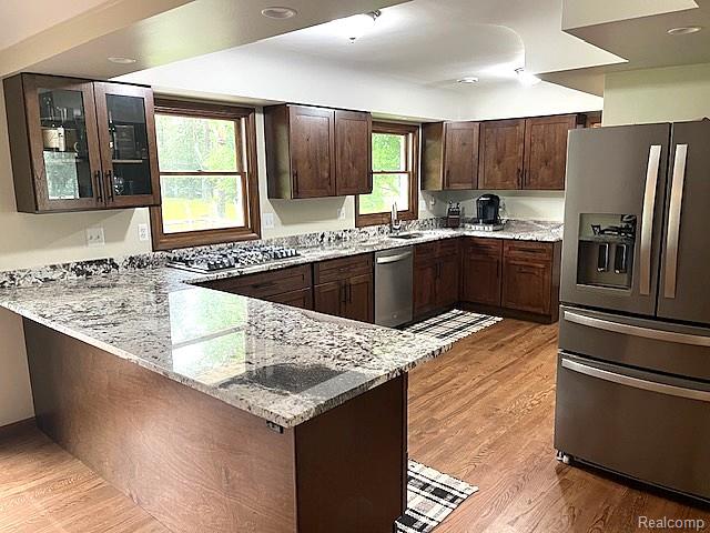 20285 29 Mile Road Ray, MI 48096 - Photo 8 of 25 Kitchen featuring wood-finish flooring, granite countertops, wood cabinetry, a built-in gas range, and a stainless steel refrigerator