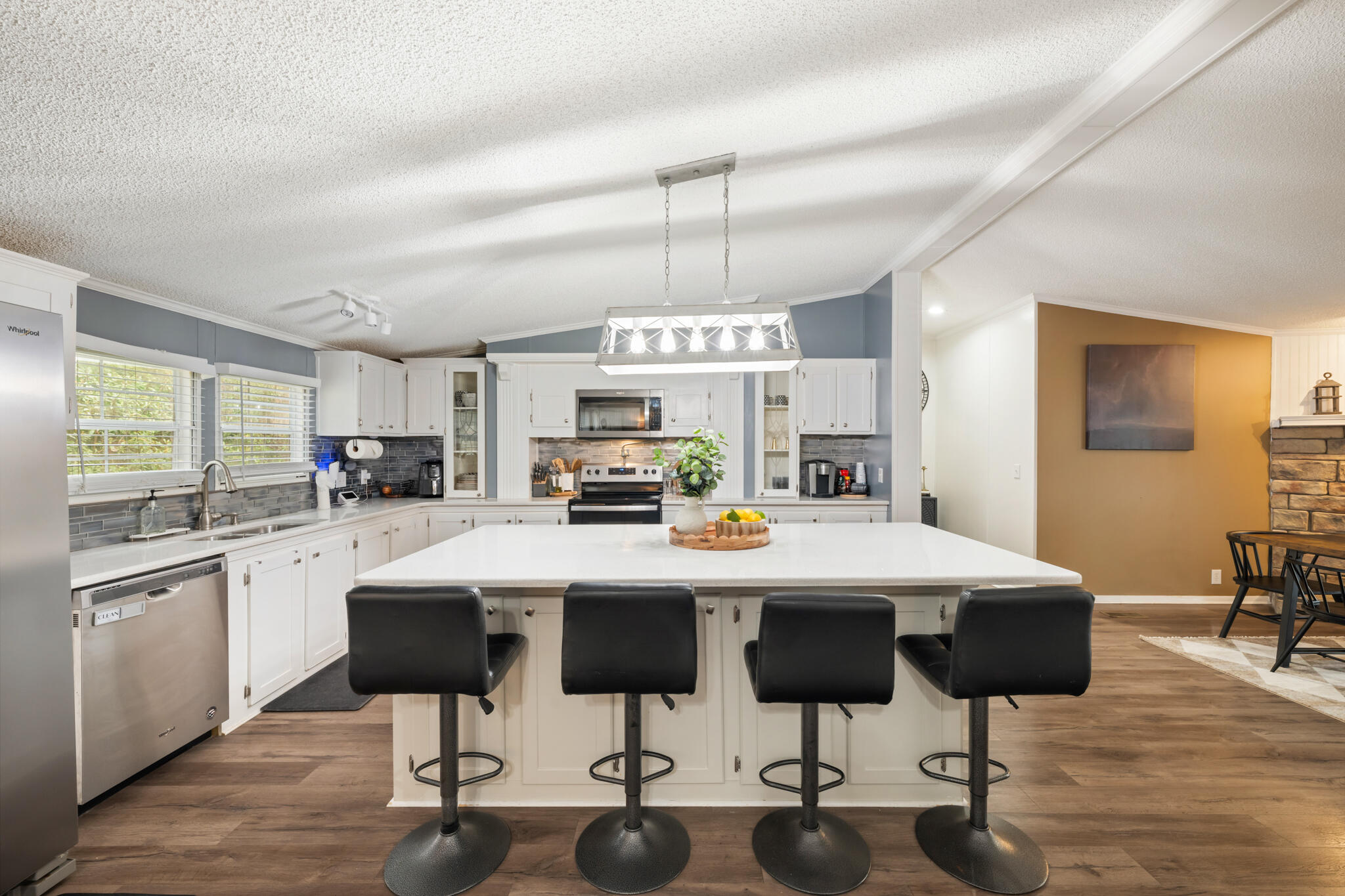 2422 Crescent Wood Road Navarre, FL 32566 - Photo 1 of 42 a kitchen with stainless steel appliances kitchen island granite countertop a table and chairs in it