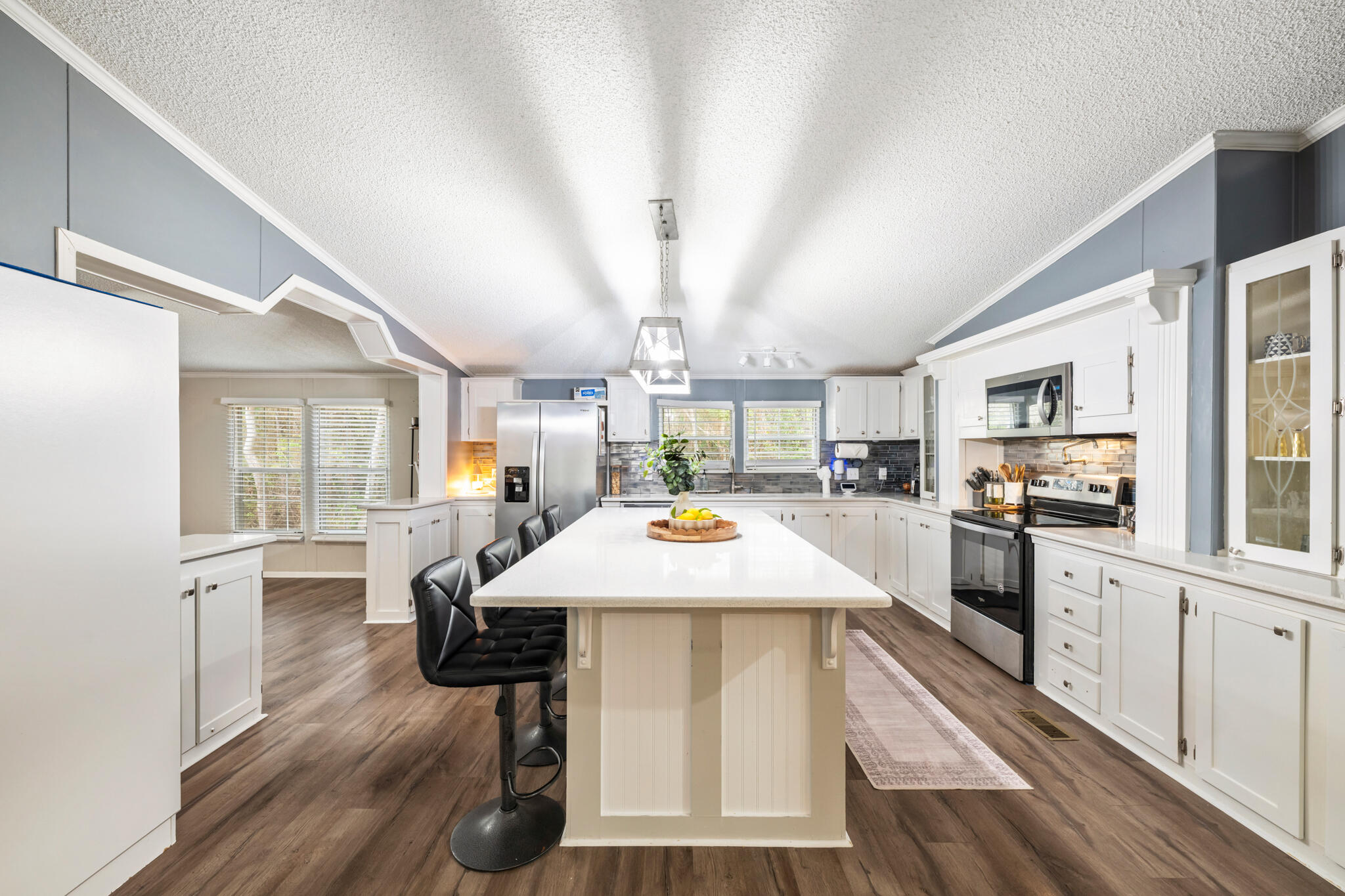 2422 Crescent Wood Road Navarre, FL 32566 - Photo 11 of 42 a large kitchen with a table chairs refrigerator and cabinets