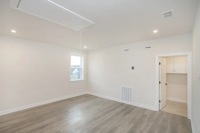an empty room with wooden floor and window