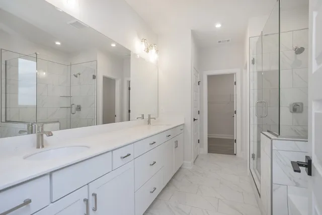 a bathroom with a double vanity sink mirror and shower