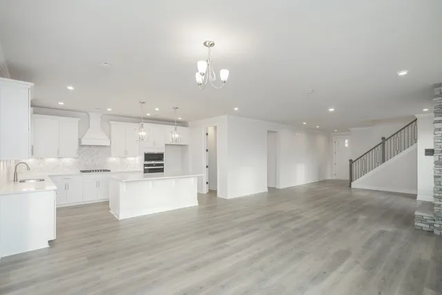 a view of kitchen with kitchen island white cabinets and wooden floor