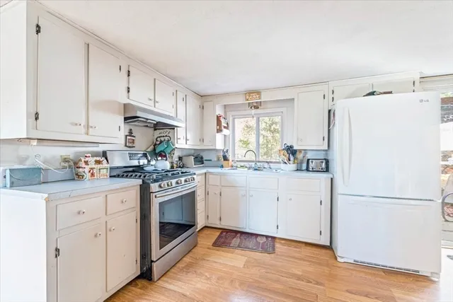 a kitchen with granite countertop white cabinets and white appliances