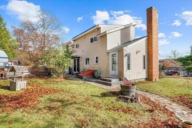 a view of a house with backyard and a tree