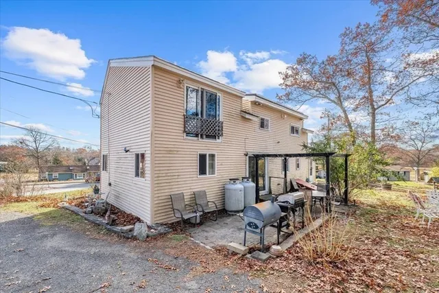 a view of a house with backyard and sitting area