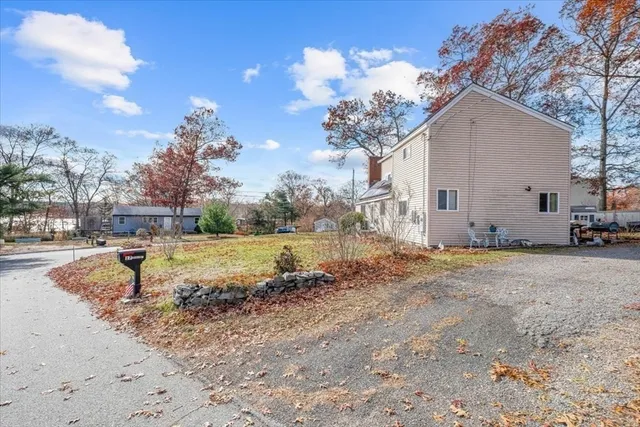 a view of a house with backyard and trees
