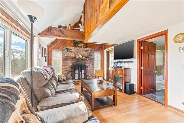 a living room with furniture a fireplace and a large window