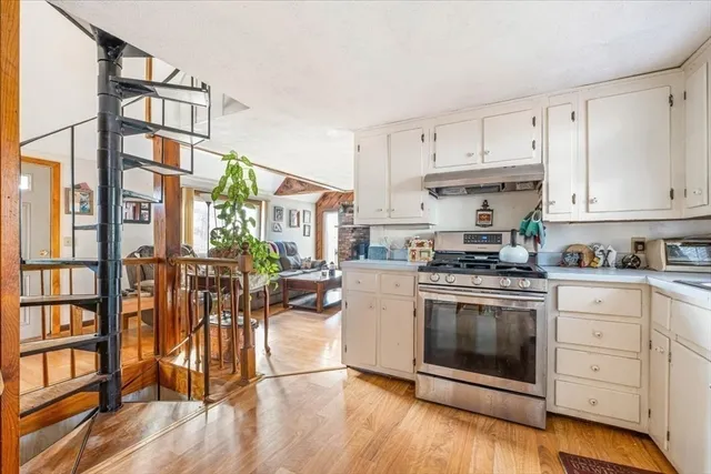 a kitchen with cabinets and wooden floor
