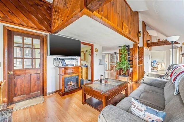 a living room with furniture a flat screen tv and a floor to ceiling window