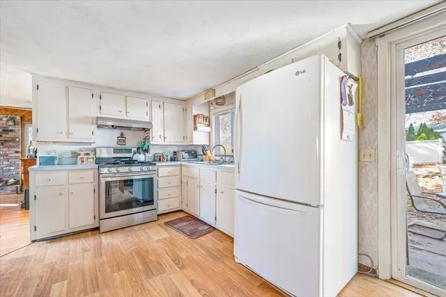 a kitchen with a refrigerator a stove top oven and white kitchen island