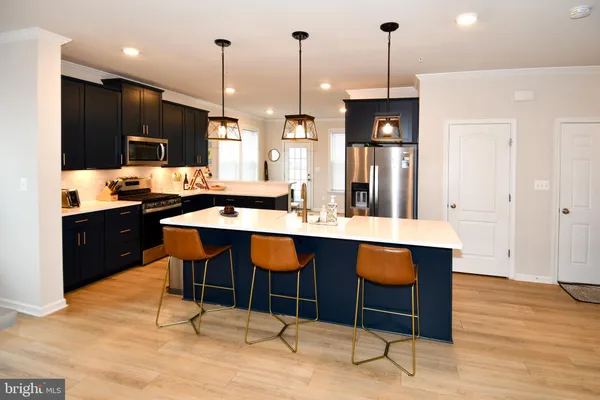 a kitchen with a dining table chairs sink and cabinets
